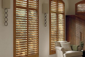 Sun shining through Brown/Natural wood shutters into living room